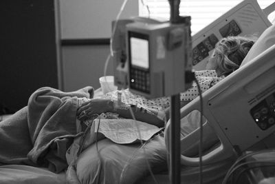 Eine schwerkranke Frau im Krankenhausbett, an künstliche Ernährung angeschlossen (Symbolbild)